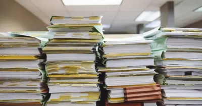 Pilhas de pastas e documentos de papel empilhadas em um escritório