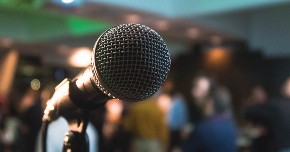 Microfone em um evento, representando palestras e ações locais de captação